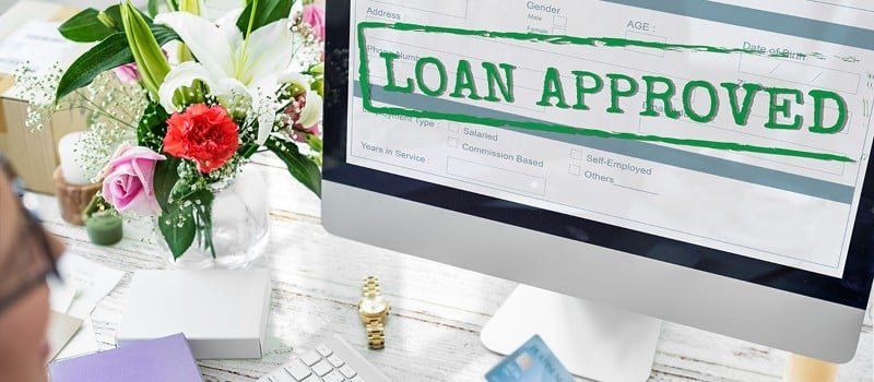 Rejected loan application paperwork and financial documents on desk